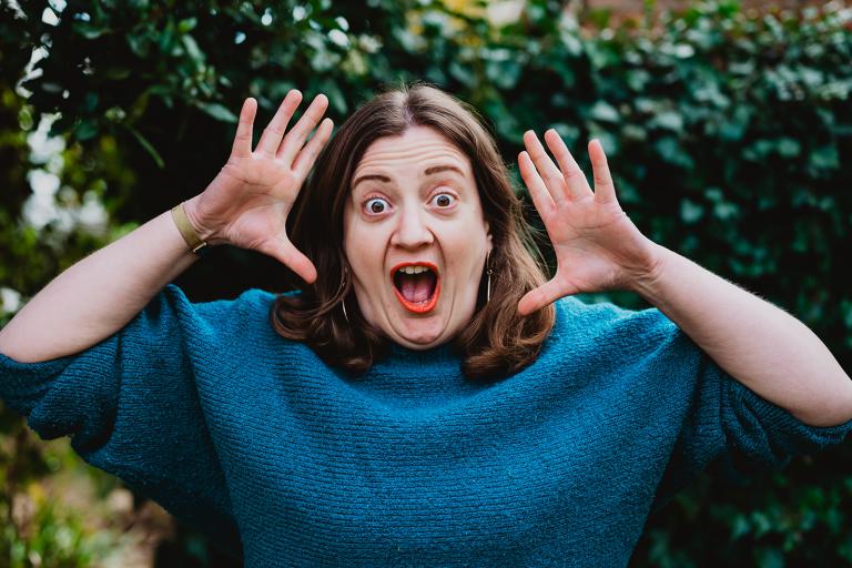 Artist, Leanne Moden making a striking pose with her hands and face