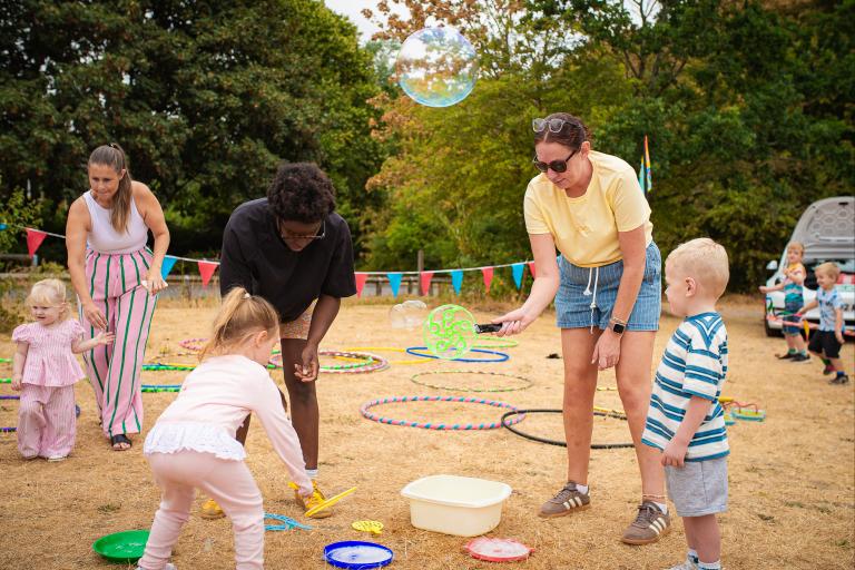 Children playing hoopla outdoors in a supervised group environment