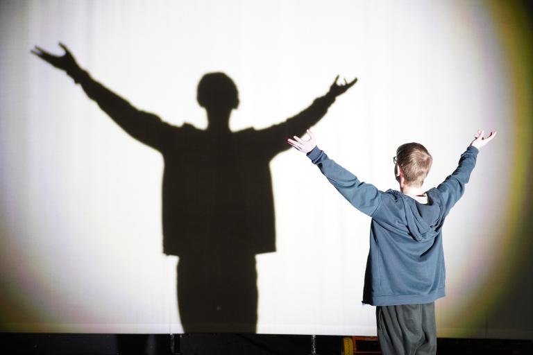 Performer producing a dramatic shadow on a screen