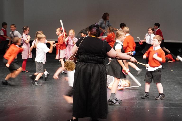 A large group of children from Holy Trinity School dancing on stage