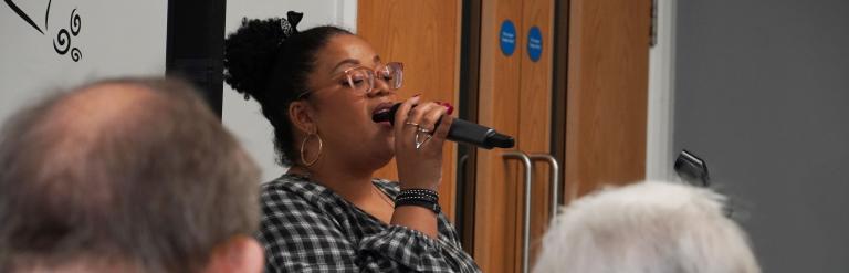 Lady using a microphone to make an announcement to an audience 
